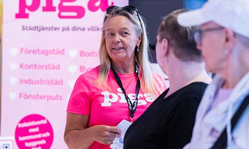 Kvinna ler och pratar med besökare på mässan Företagardagarna i Ängelholm